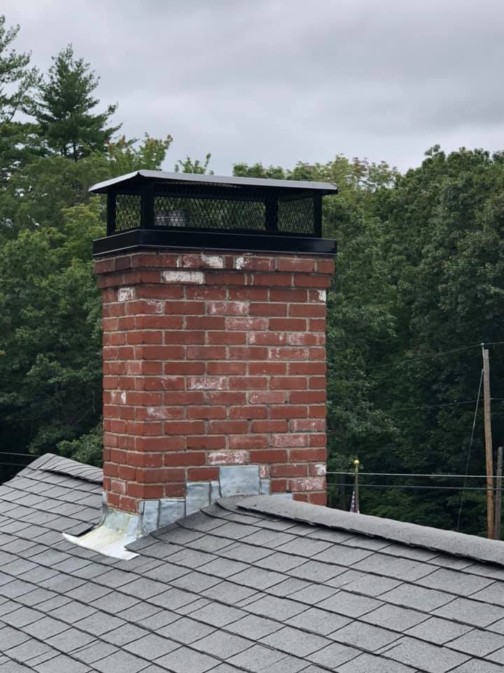 Custom Chimney Cap Kittery ME Custom black chimney cap installation on brick chimney in Kittery, ME by Frechette Chimney Sweeping, helping protect against rain, animals, and chimney damage.
