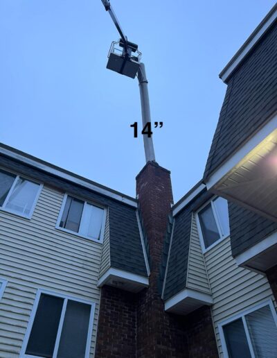 Installing a new stainless steel chimney liner in Scarborough, ME using a lift.