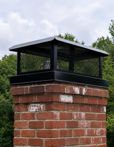 New black mesh chimney cap replacement on a brick chimney in Kennebunk, ME.